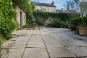 Terrasse en dalles posées sur sable avec joints ouverts et légères dénivellations visibles