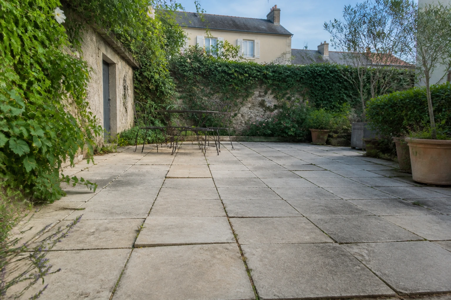 Terrasse en dalles posées sur sable avec joints ouverts et légères dénivellations visibles