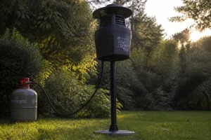 Piège à moustique professionnel posé dans un jardin au coucher du soleil