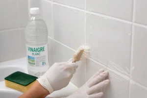 Nettoyage des joints de carrelage à la brosse avec une pâte de bicarbonate dans une salle de bain