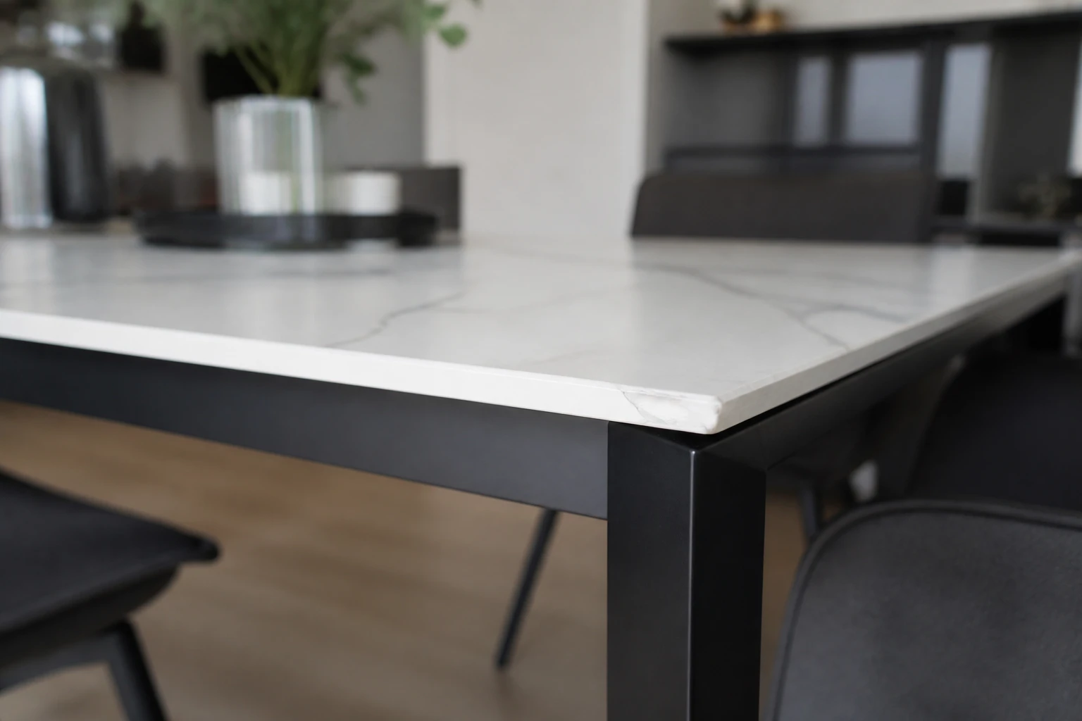 Gros plan sur un angle de table en céramique effet marbre avec éclat sur l'arête du plateau